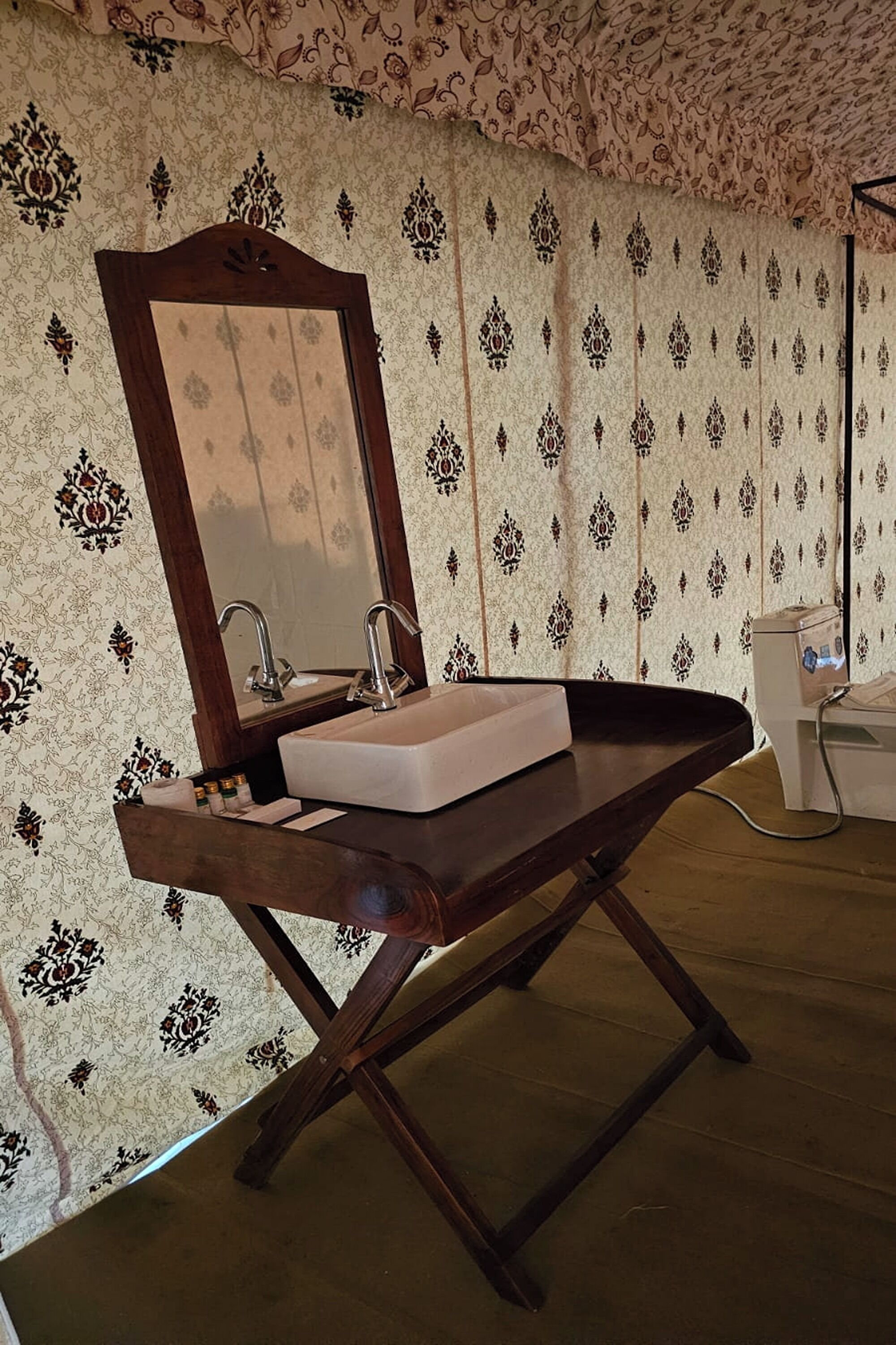 A bathroom with a wooden vanity, a mirror, and a sink.