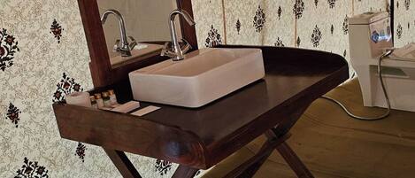 A bathroom with a wooden vanity, a mirror, and a sink.
