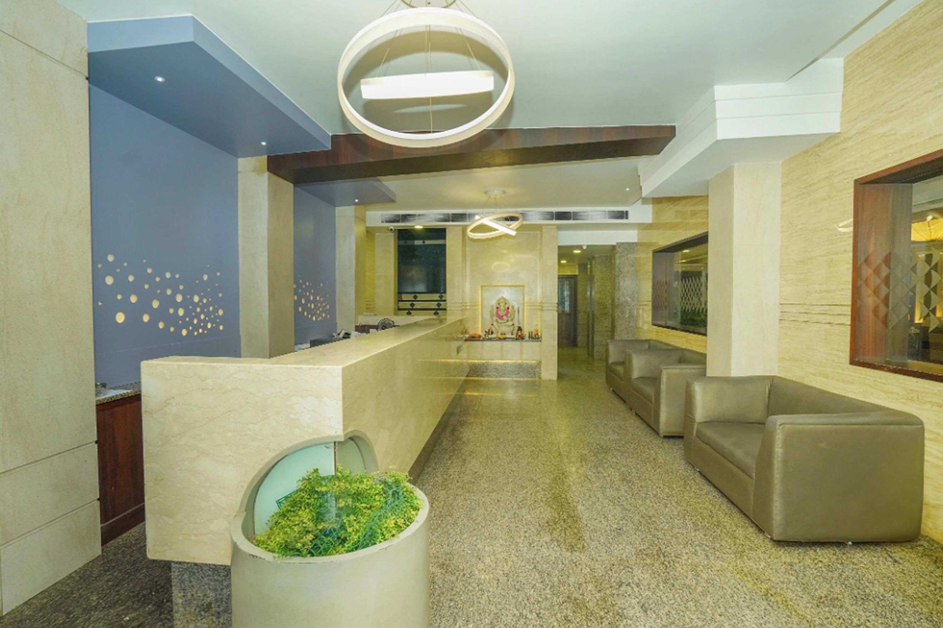 Eine moderne Lobby mit einer Rezeption, einer Sitzgelegenheit und einer Wand mit kreisförmigen Mustern.