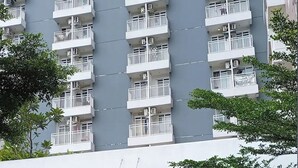 A multi-story building with white balconies and air conditioning units. - Jasmine Park Jp Rooms (Dramaga)