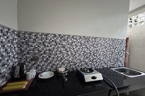 Eine Küche mit schwarzem Arbeitsplatz, Spüle, Herd und gefliestem Spritzschutz.