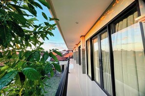 A balcony with a view of the sky and neighboring buildings. - Sekar Tunjung Guest House Seminyak Bali (Denpasar)