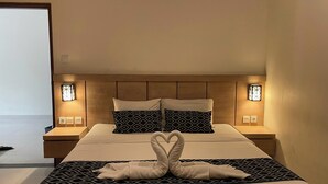 A hotel room with a bed, two nightstands, and wall-mounted lights. - Singgah Hotel Seminyak (Seminyak)