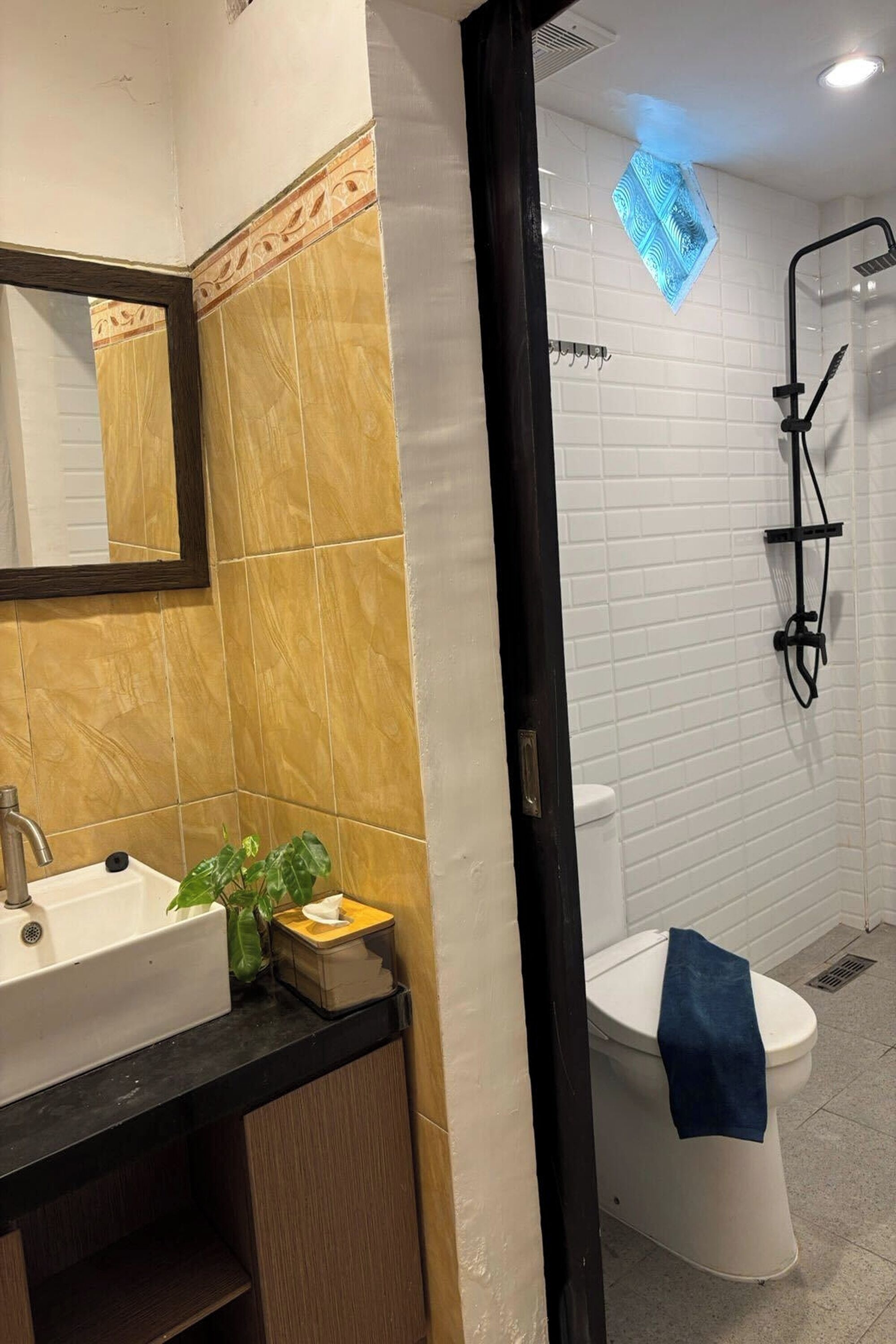 A bathroom with a sink, mirror, and shower.
