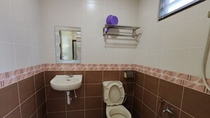 Un baño con lavamanos, inodoro y espejo.