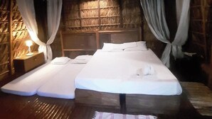 A room with two beds, a wooden ceiling, and a thatched wall. - Surfer'S Villa (San Juan)