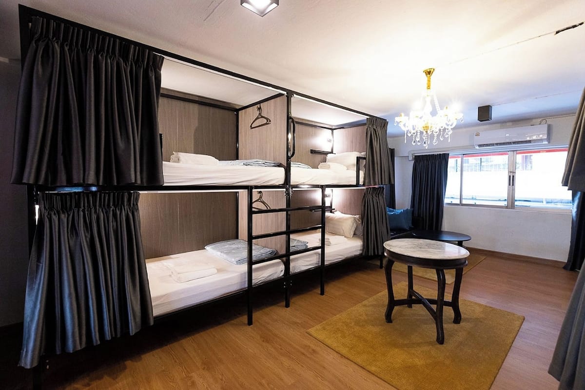 Habitación con literas, una mesita pequeña y un candelabro.