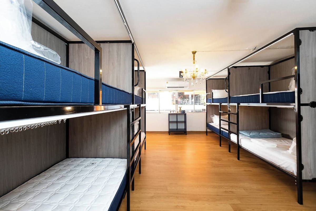 Un dormitorio con literas, suelo de madera y un candelabro.