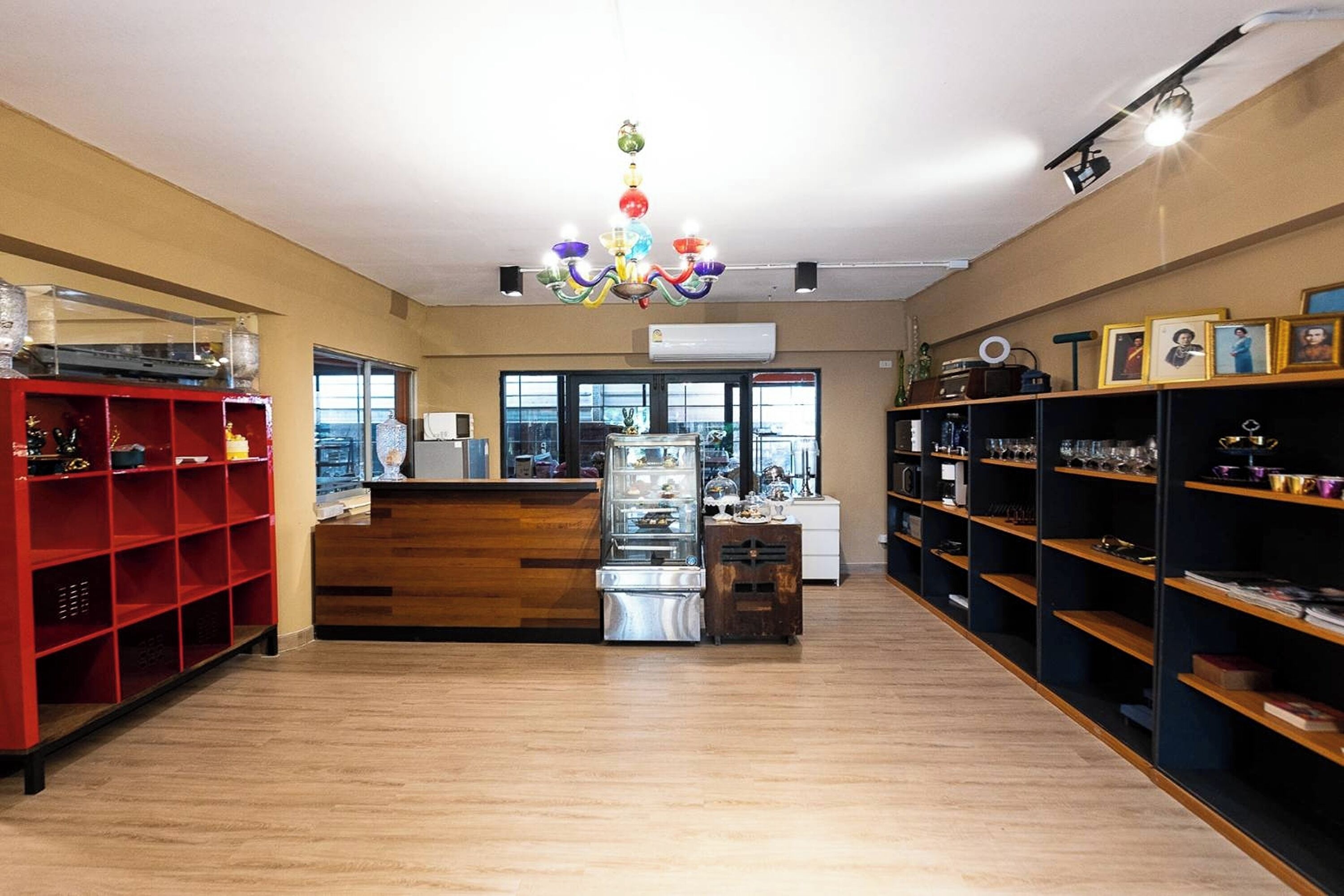 A spacious room with wooden flooring, a central counter, and shelves on both sides.