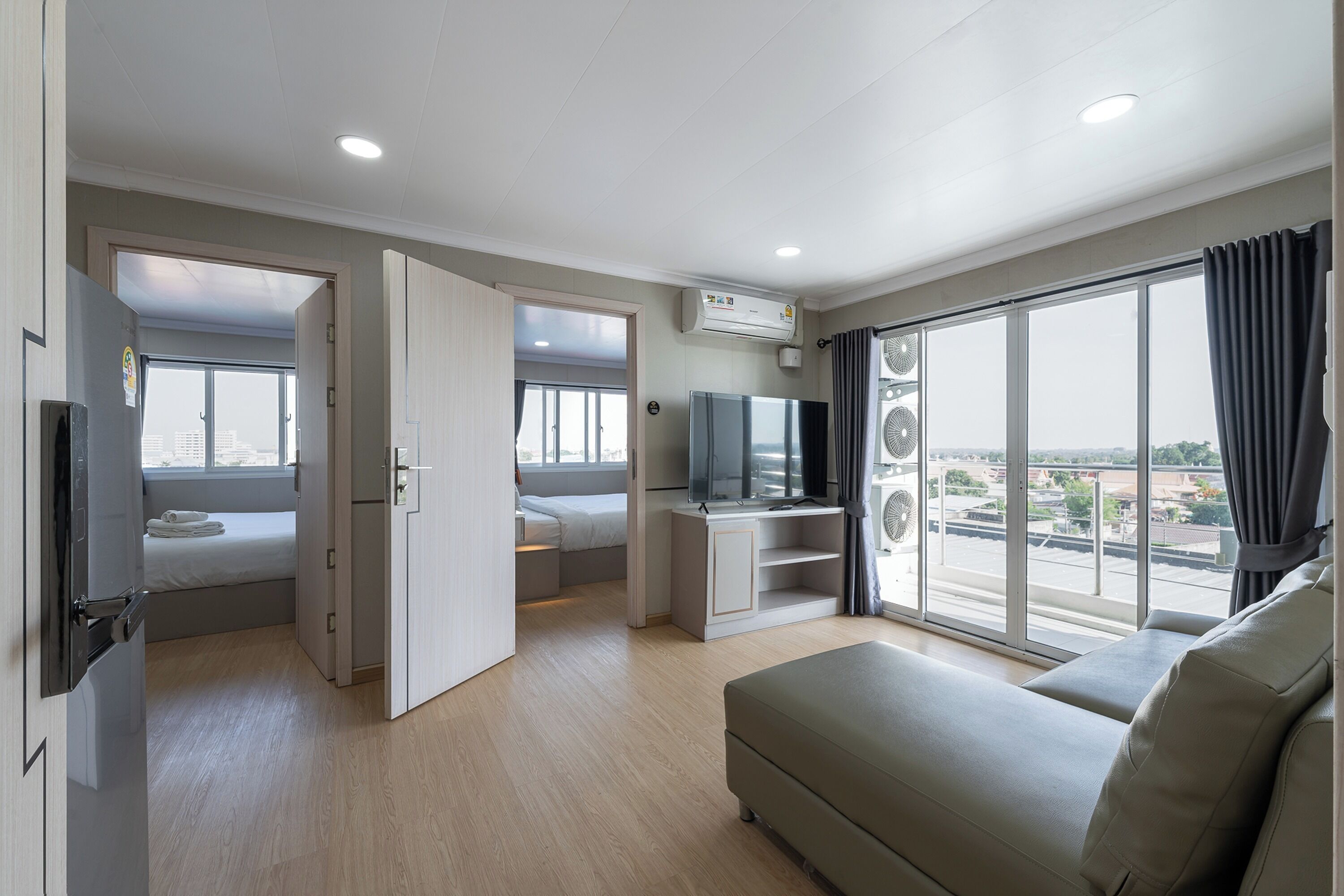 Una habitación de hotel moderna con balcón, televisión y cama.