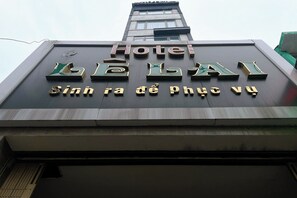 Een hotelschild met de naam "Hotel Linh Thanh" en de tekst "Sình ra de phúc vũ" in Vietnamees.