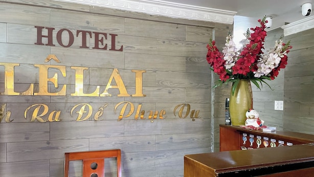 Una recepción de hotel con un fondo de madera y un cartel que dice "HOTEL LELAI".