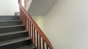 Una escalera con barandillas de madera y una pared blanca.