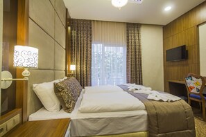 A hotel room with a bed, a television, and a window with curtains. - Tint Residence Taksim Deluxe (Istanbul)