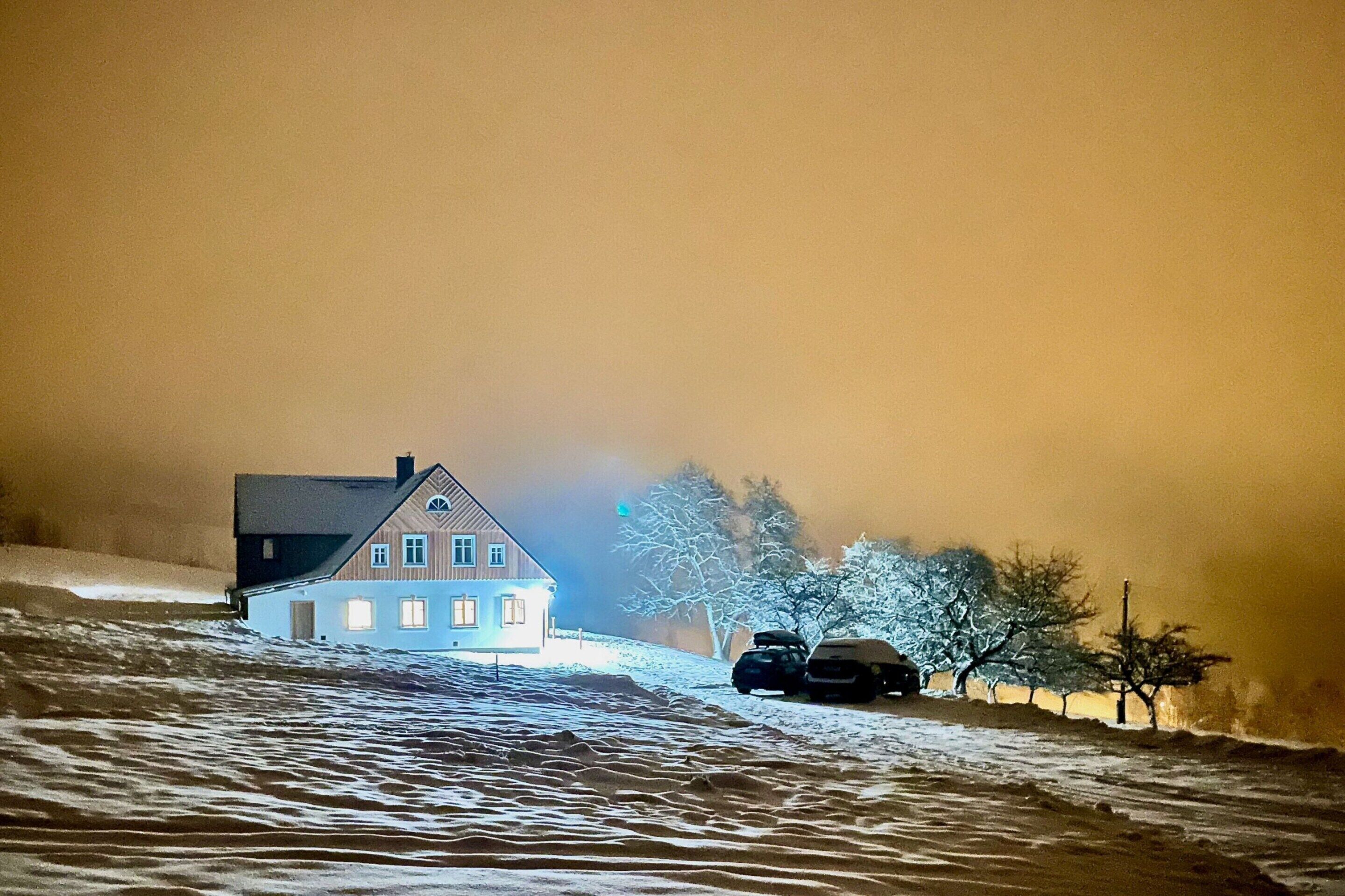 Ein Haus mit geneigtem Dach, Schornstein und Garage.