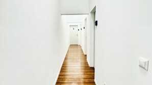 A narrow hallway with white walls and a wooden floor, leading to a door marked with the number 5. - Comfortable Room for 2, Close to Atzgersdorf (Vienna)