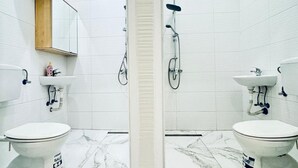 A bathroom with two toilets, a sink, a mirror, and a shower. - Convenient Stay Room for 2, 11 Min to Atzgersdorf (Vienna)