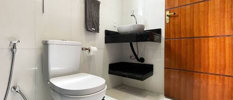 Une salle de bain avec des toilettes, un lavabo et une douche.