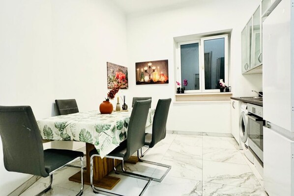 A dining area with a table, chairs, and a vase of flowers.