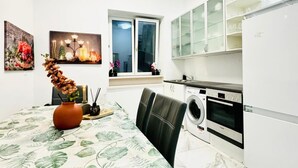 A modern kitchen with a dining table, a washing machine, and a window with a view. - Beautiful Room Close to Atzgersdorf (Vienna)