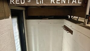 A narrow stairwell with a sign reading "RED'S LIL' RENTAL" at the top. - Ranch House in peaceful Little Hocking close to the Ohio River. Heat/AC, WiFi (Little Hocking)