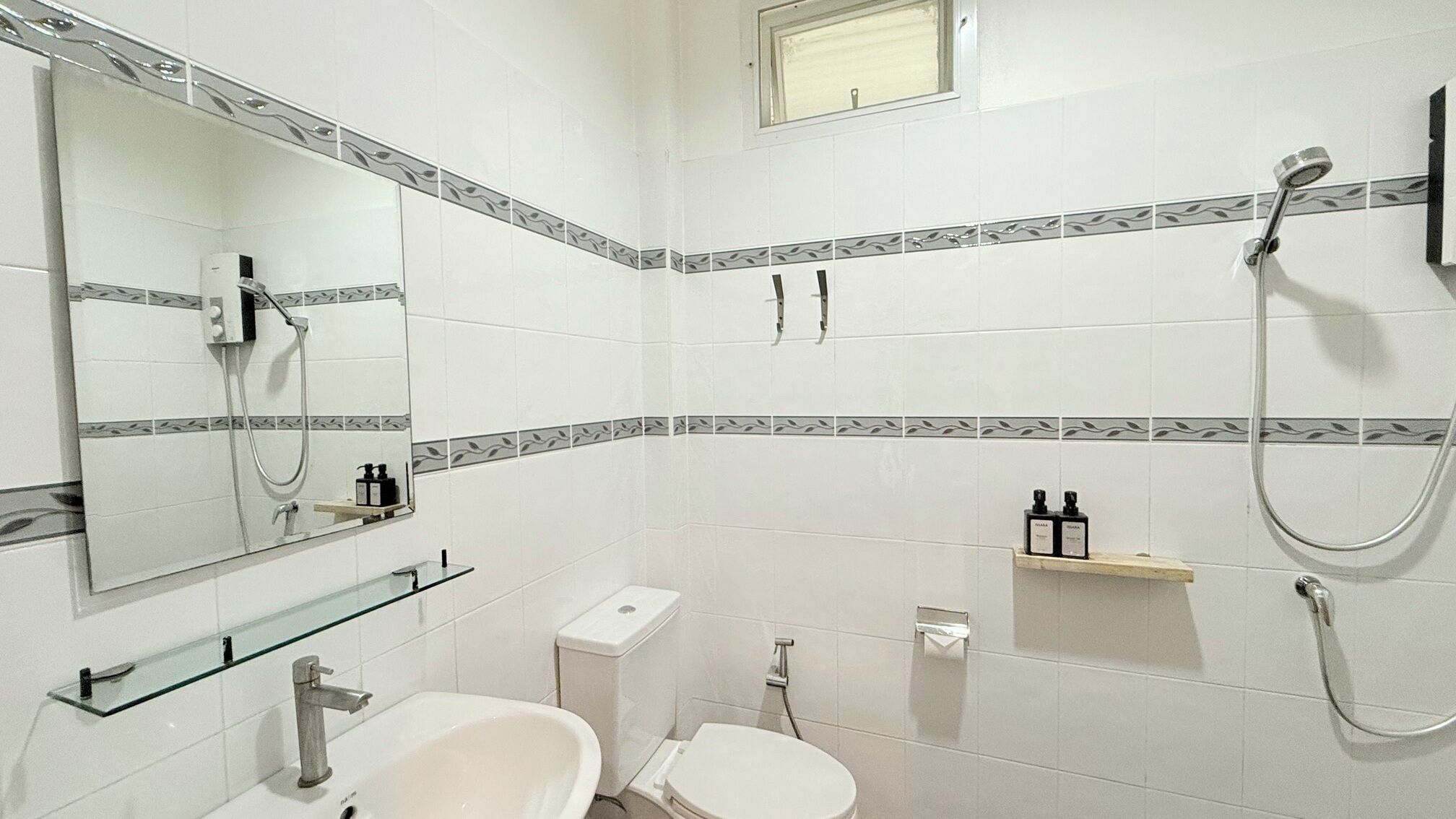 A bathroom with a toilet, bidet, and a shower.
