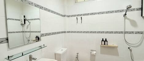 A bathroom with a toilet, bidet, and a shower.