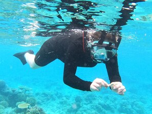Una persona sumergida en un entorno azul y transparente, posiblemente una piscina o un espacio acuático controlado.
