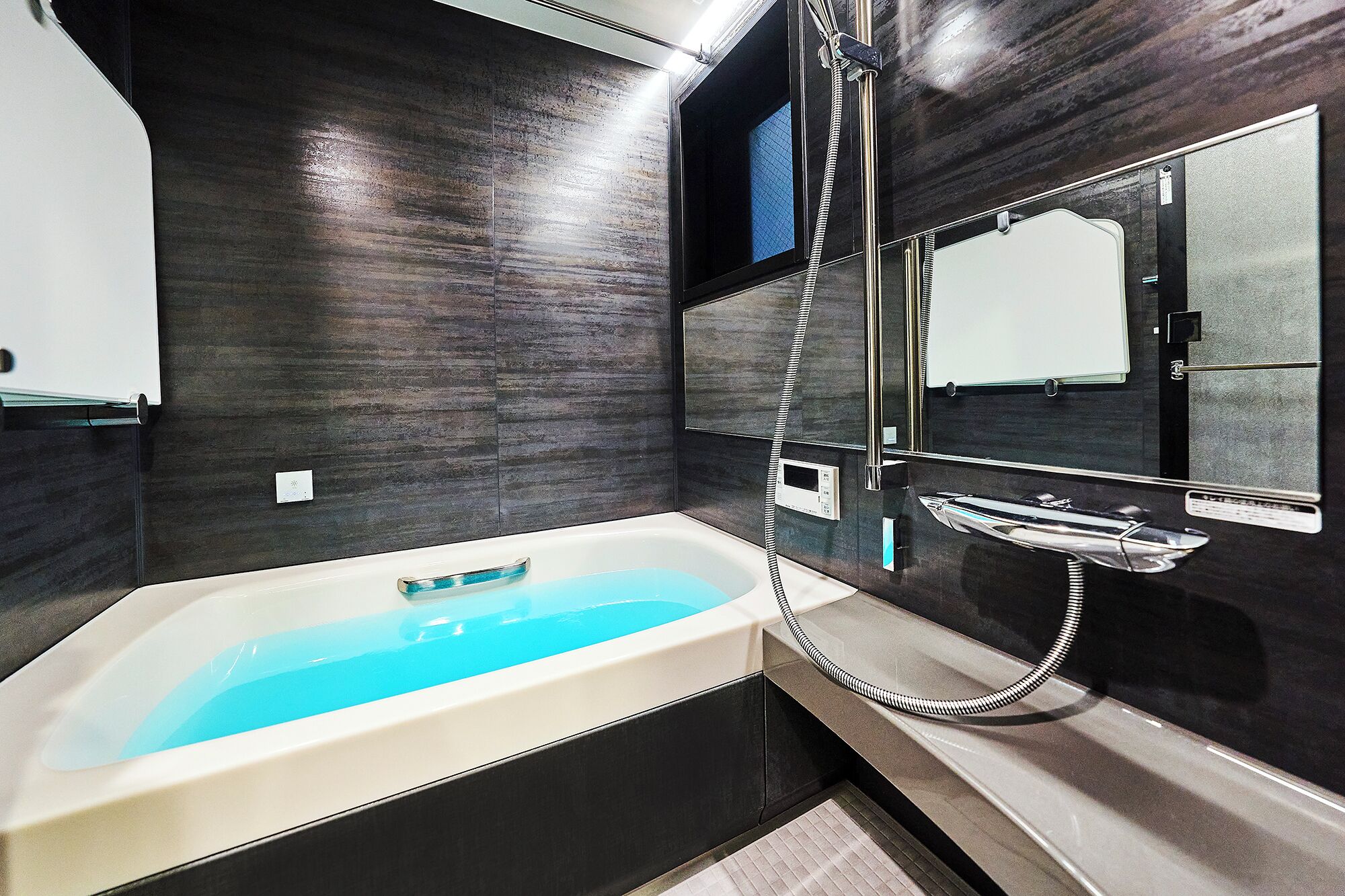 A modern bathroom with a freestanding bathtub, a glass-enclosed shower, and a large mirror.