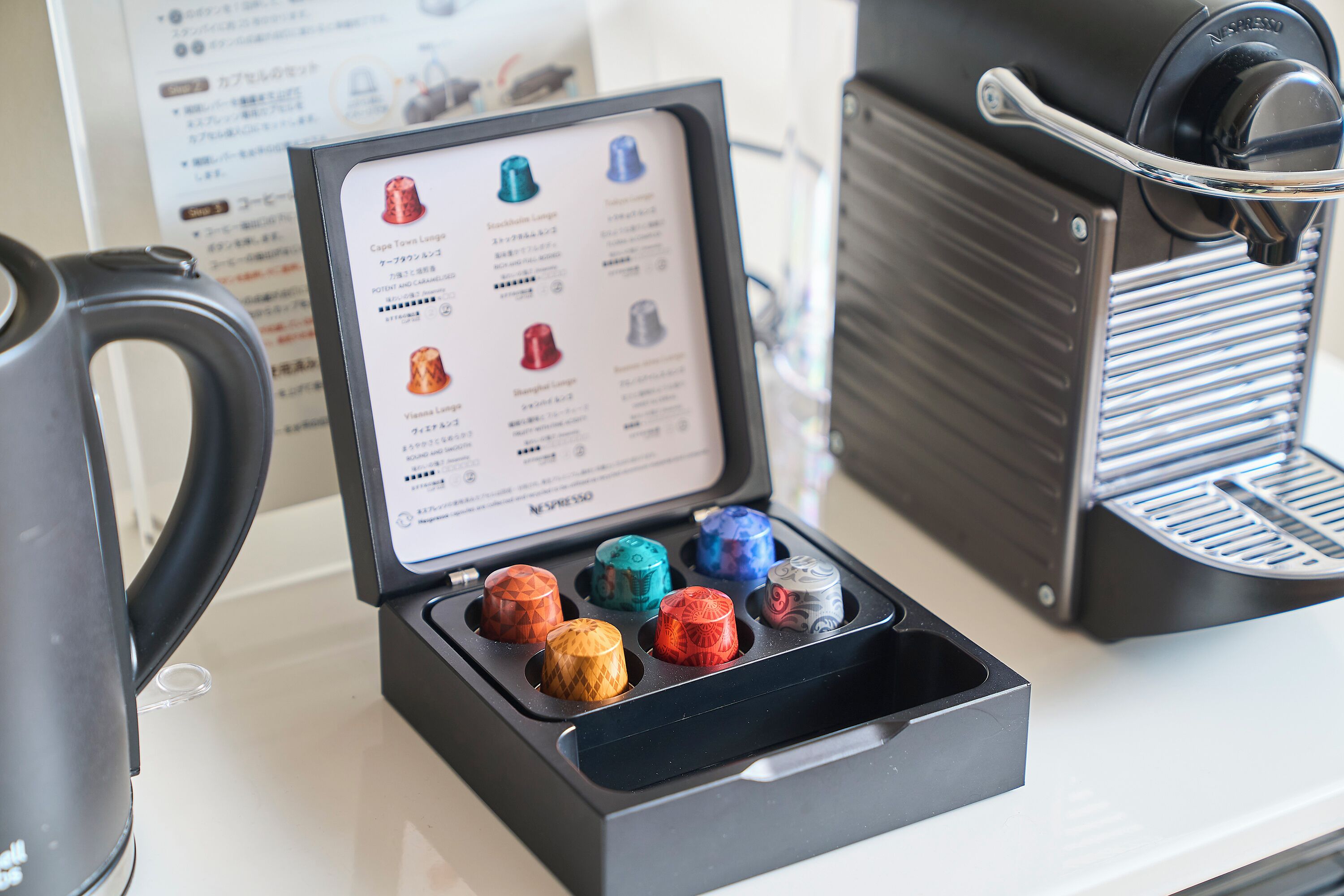 A coffee machine with a selection of coffee pods in a box.
