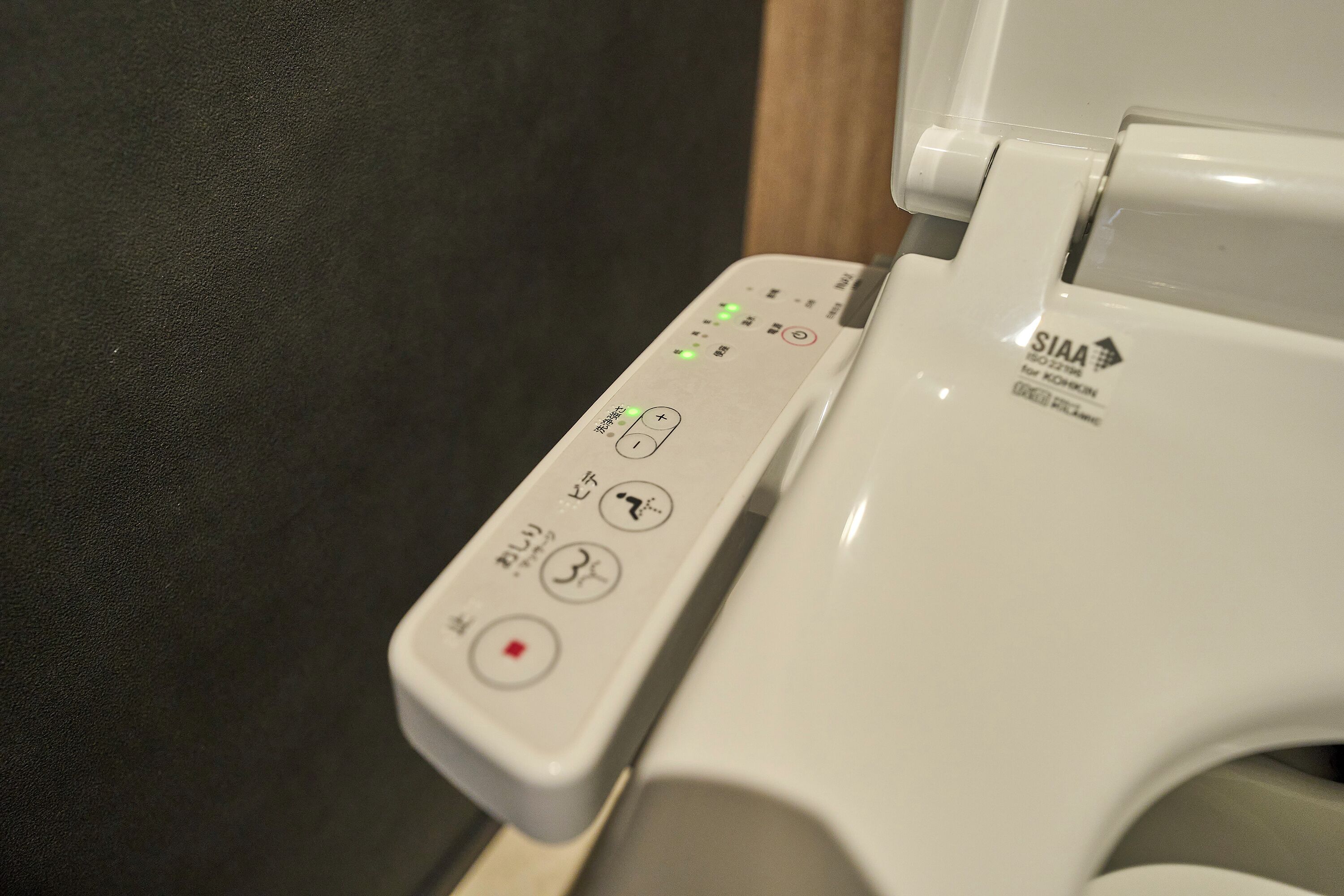 A toilet with a control panel featuring various buttons and indicators.