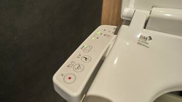 A toilet with a control panel featuring various buttons and indicators.