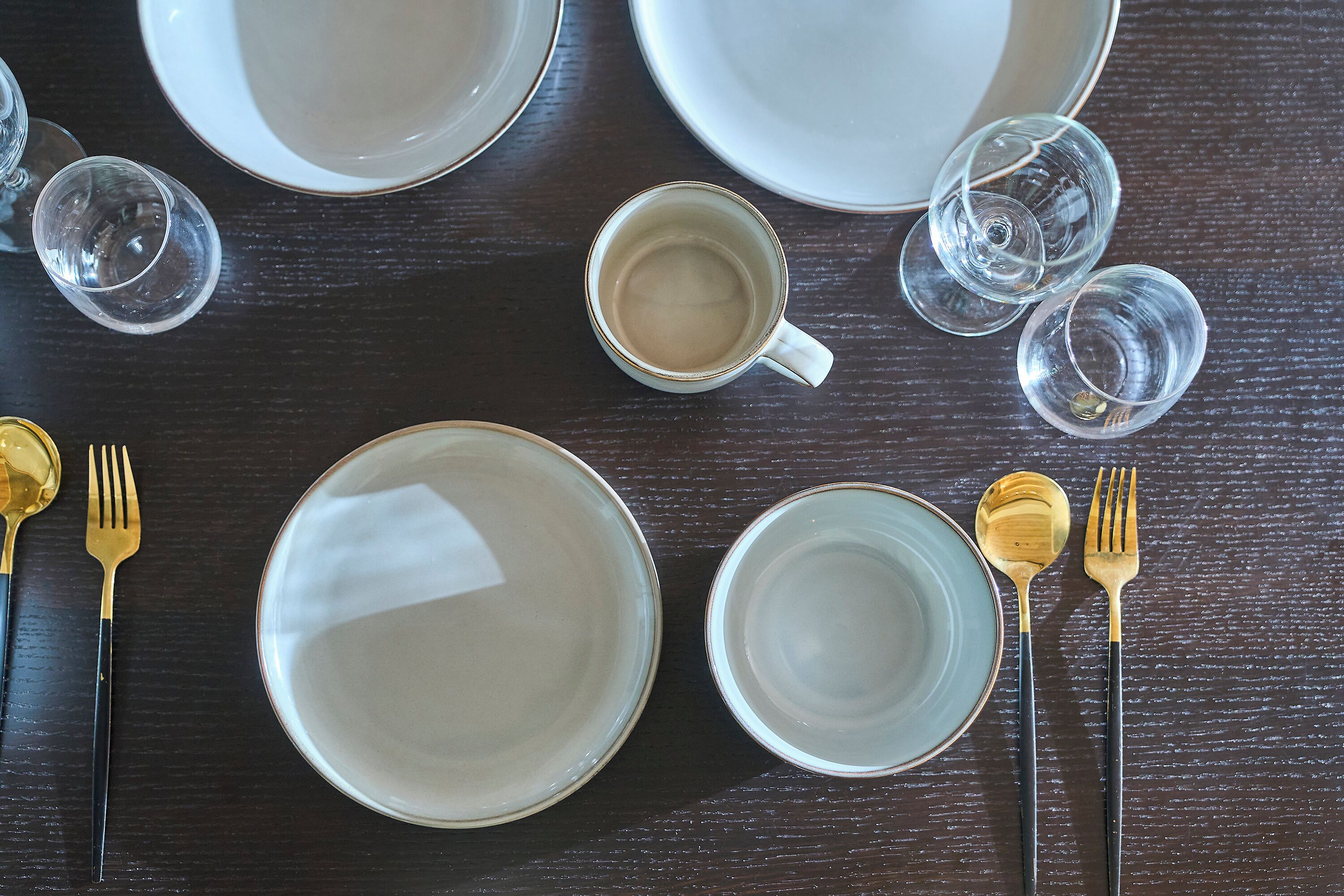 A dining table set with plates, glasses, and cutlery.