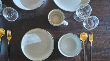 A dining table set with plates, glasses, and cutlery.