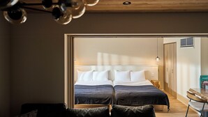 Une chambre moderne avec deux lits, un plafond en bois et une petite table avec des chaises.