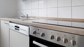 Una cucina con lavastoviglie, lavello e piano cottura con comandi multipli.