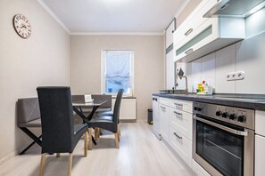 Une cuisine moderne avec un coin repas, des appareils électroménagers en acier inoxydable et une fenêtre offrant une belle vue.