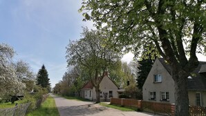 A residential street with houses, a sidewalk, and trees. - Apartment 'Kropp' with Private Terrace, Private Garden and Wi-Fi (Knorrendorf)