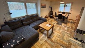 Ein gemütliches Wohnzimmer mit einer Couch, einem Esstisch und einem Kamin.