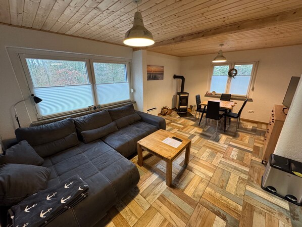 A cozy living room with a sofa, dining table, and a fireplace.