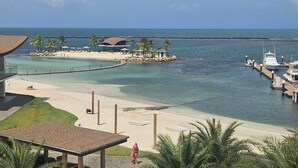 Une station balnéaire dotée d’une plage, d’un port de plaisance et d’une petite île abritant des constructions.