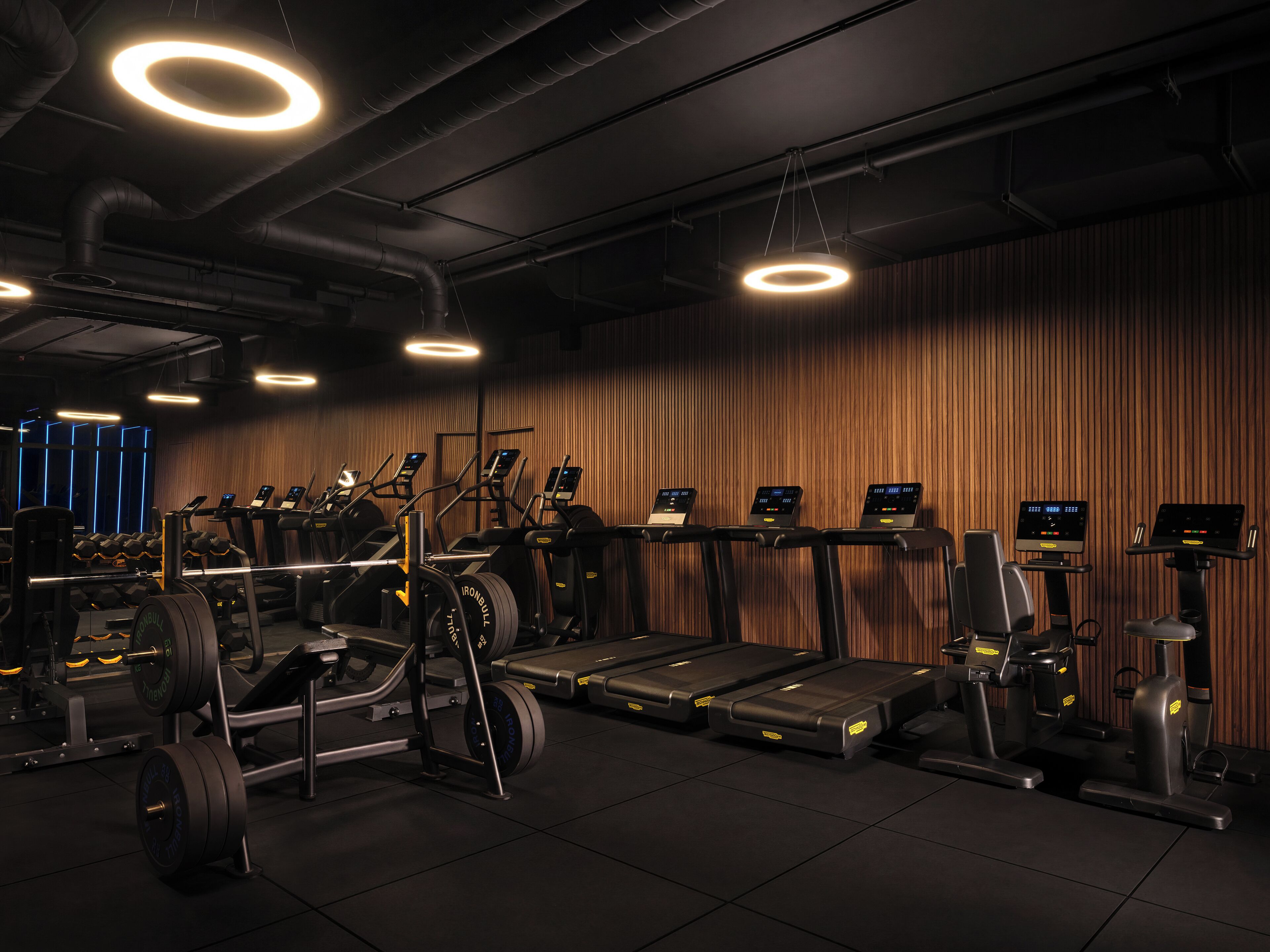 Academia com esteiras, elípticos e equipamentos de musculação.