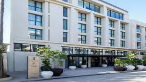 Ein modernes Hotel mit einer symmetrischen Fassade, großen Fenstern und einem zentralen Eingang.