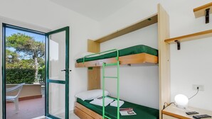 A dorm-style room with bunk beds, a desk with a lamp, and a sliding glass door to an outdoor area. - Le Onde Apartment 2 with Pool n.115/a, Otranto, Italy (Otranto)