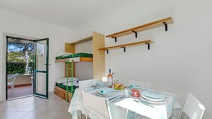 A compact room with a bunk bed, a dining table set for two, and a sliding glass door leading to an outdoor area. - Le Onde Apartment 2 with Pool n.115/a, Otranto, Italy (Otranto)