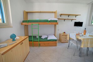 A bunk bed with a ladder, a desk with a chair, a television, and a dining table set for two. - Le Onde Apartment 1 with Pool n.114/a, Otranto, Italy (Otranto)