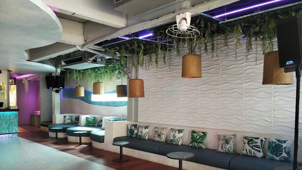 Un espace lounge moderne comprenant des sièges, un bar et des plantes décoratives.