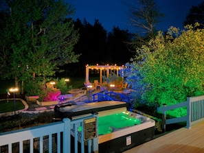 Ein Whirlpool mit Sicherheitsregeln, ein Pavillon mit Lichterketten und eine Holzterrasse.