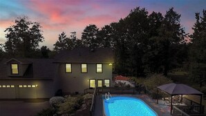 Une propriété résidentielle dotée d’une piscine, d’un patio couvert et d’un garage.