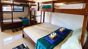 A bunk bed room with a window, a desk, and a patterned rug. - Hapitanan Siargao (General Luna)